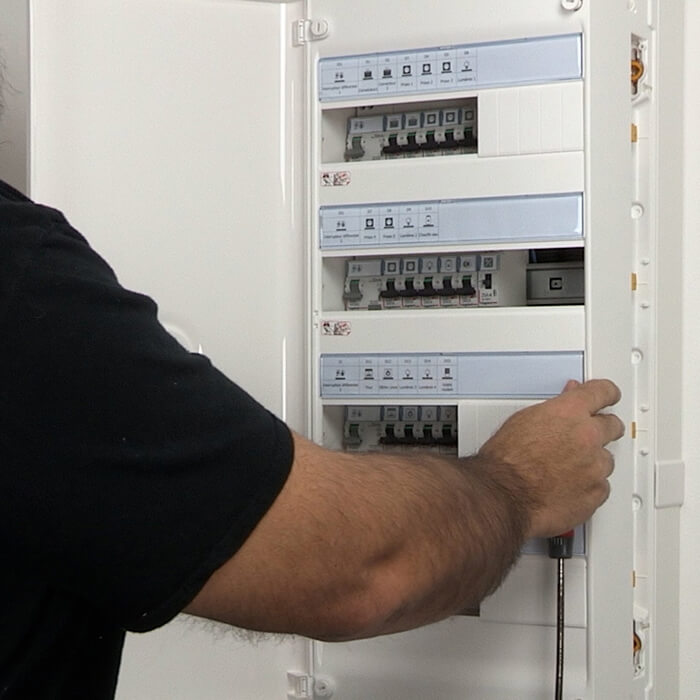 Intervenant contrôlant les commandes d’un tableau électrique