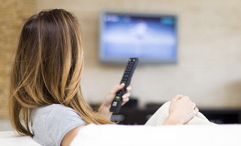 femme telecommande tv salon 474x287