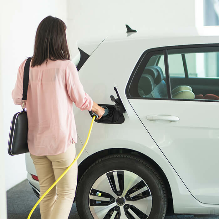 femme recharge voiture parking collectif 700x700