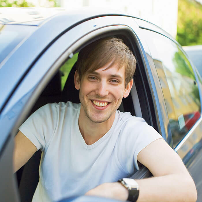 homme sourire dans voiture 700x700